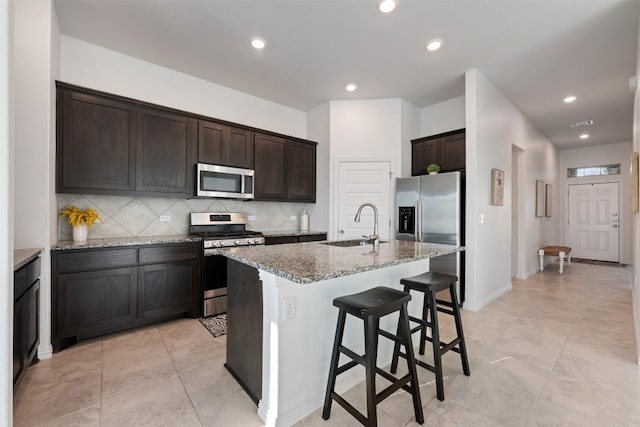 13002 Stanford Dr Unit 40, Austin, TX 78748 - kitchen with stainless steel appliances, a sink, light stone countertops, backsplash, and dark brown cabinetry