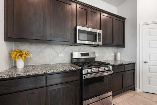 13002 Stanford Dr Unit 40, Austin, TX 78748 - kitchen featuring stainless steel appliances, dark brown cabinets, decorative backsplash, and stone countertops