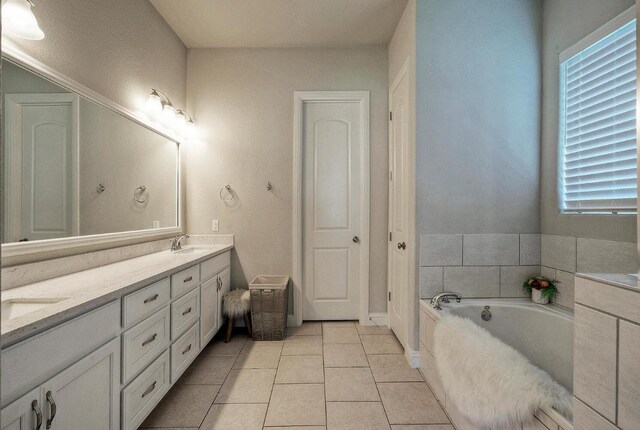 20304 Thumper Jack Ct, Pflugerville, TX 78660 - bathroom with double vanity, a garden tub, and tile patterned floors