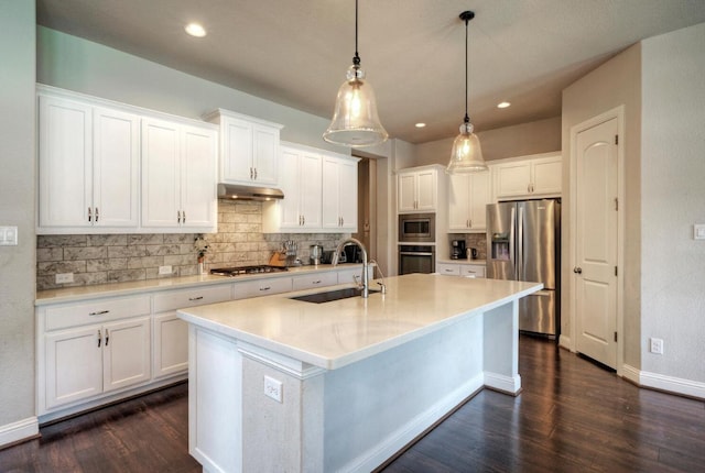 20304 Thumper Jack Ct, Pflugerville, TX 78660 - kitchen with appliances with stainless steel finishes, a sink, under cabinet range hood, dark wood finished floors, and recessed lighting