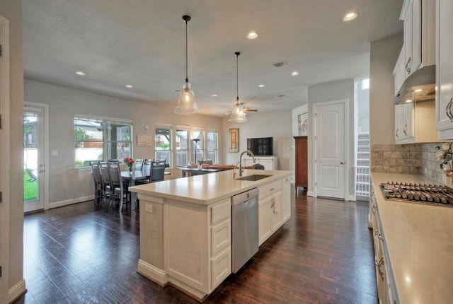 20304 Thumper Jack Ct, Pflugerville, TX 78660 - kitchen with appliances with stainless steel finishes, a sink, under cabinet range hood, dark wood finished floors, and light countertops
