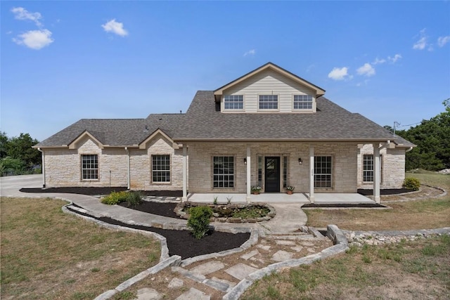 206 High Plains Dr, Dripping Springs, TX 78620 - view of front of home with stone siding, a shingled roof, and a patio