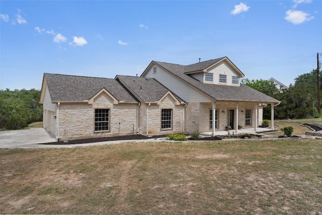 206 High Plains Dr, Dripping Springs, TX 78620 - view of front facade with stone siding, covered porch, roof with shingles, a front lawn, and driveway