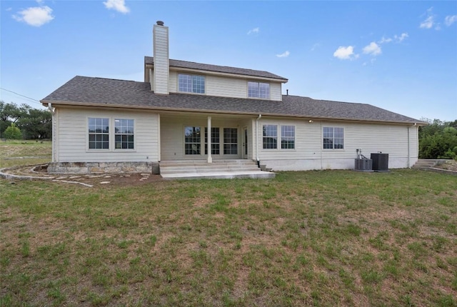 206 High Plains Dr, Dripping Springs, TX 78620 - rear view of house with a yard, a chimney, and central AC unit