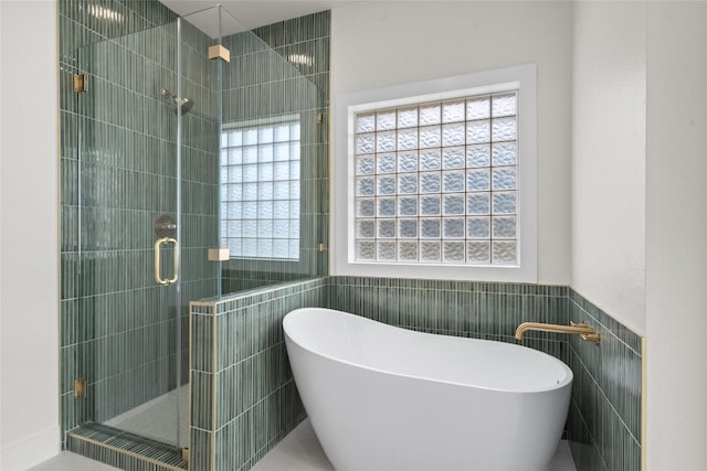 206 High Plains Dr, Dripping Springs, TX 78620 - full bath with tile walls, a shower stall, a freestanding bath, and a wainscoted wall