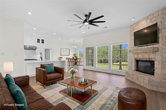 206 High Plains Dr, Dripping Springs, TX 78620 - living room featuring a ceiling fan, a stone fireplace, light wood-type flooring, and recessed lighting