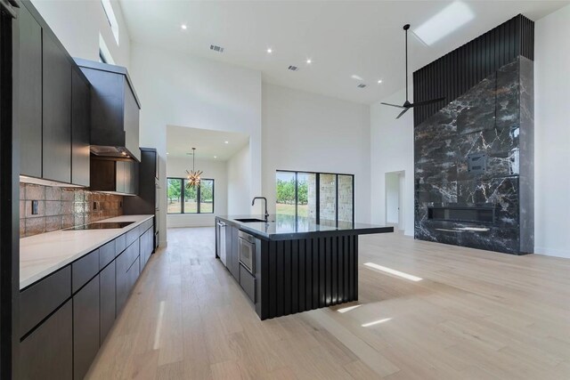 125 Azalea Loop, Horseshoe Bay, TX 78657 - kitchen featuring a high ceiling, black electric cooktop, modern cabinets, light wood finished floors, and a fireplace