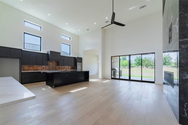 125 Azalea Loop, Horseshoe Bay, TX 78657 - kitchen with a high ceiling, open floor plan, dark cabinets, a ceiling fan, and modern cabinets