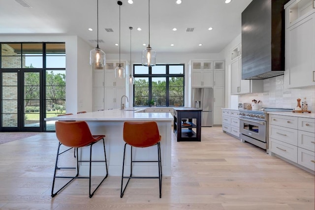 4255 Fm 3405, Georgetown, TX 78633 - kitchen featuring wall chimney exhaust hood, appliances with stainless steel finishes, a large island with sink, healthy amount of natural light, and recessed lighting