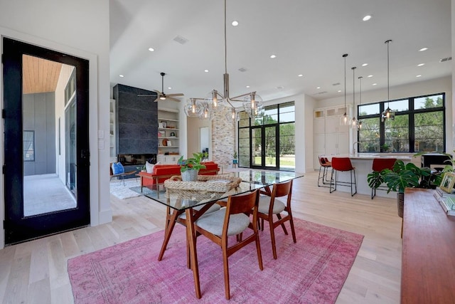 4255 Fm 3405, Georgetown, TX 78633 - dining area featuring a chandelier, light wood-type flooring, a tiled fireplace, and recessed lighting