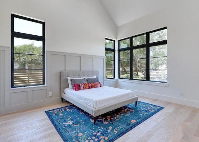 4255 Fm 3405, Georgetown, TX 78633 - bedroom featuring a decorative wall, lofted ceiling, light wood-type flooring, and wainscoting