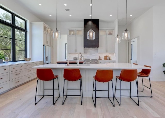 4255 Fm 3405, Georgetown, TX 78633 - kitchen featuring wall chimney range hood, backsplash, light countertops, recessed lighting, and light wood finished floors