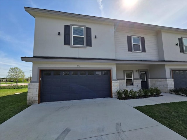 2105 Tiger Trl Unit 101, Round Rock, TX 78665 - view of front of home with stone siding, an attached garage, concrete driveway, stucco siding, and a front lawn