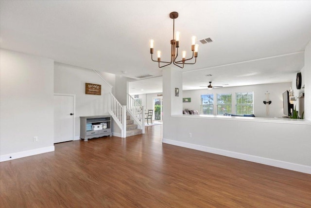 100 N Prairie Ln, Georgetown, TX 78633 - unfurnished living room with a chandelier, wood finished floors, baseboards, a ceiling fan, and stairs
