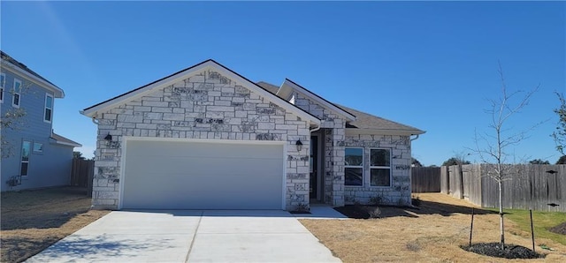 813 Vaughn St, Georgetown, TX 78628 - view of front of home featuring stone siding, an attached garage, and driveway