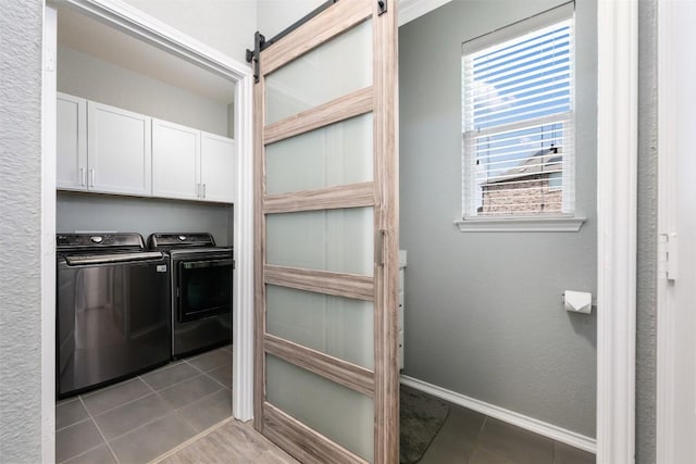 1312 Backcountry Dr, Leander, TX 78641 - laundry area featuring separate washer and dryer, cabinet space, tile patterned floors, and baseboards
