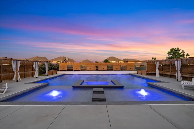 1312 Backcountry Dr, Leander, TX 78641 - pool at dusk with a fenced backyard, a patio, and a pool with connected hot tub