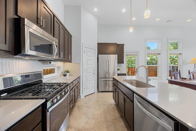 1402 E 11th St, Austin, TX 78702 - kitchen with stainless steel appliances, a sink, dark brown cabinetry, concrete flooring, and decorative backsplash