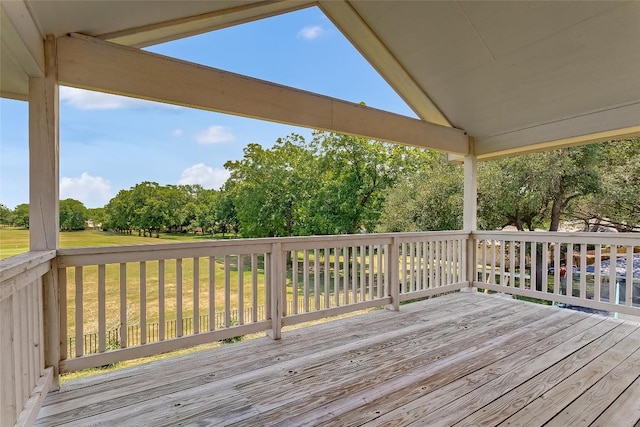 deck with view of scattered trees and a yard
