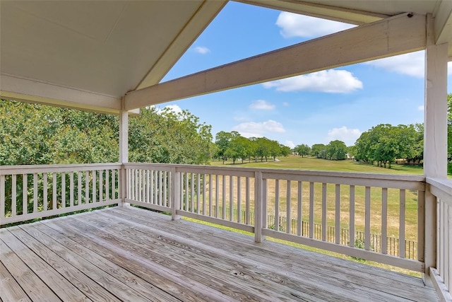 wooden deck with a lawn and view of scattered trees