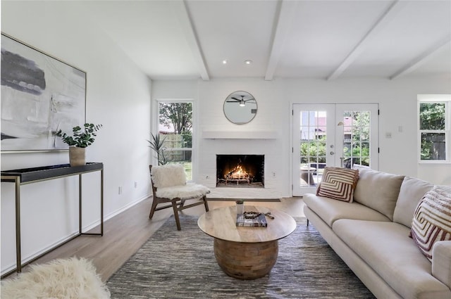 2603 Carlow Dr, Austin, TX 78745 - living area featuring beamed ceiling, wood finished floors, a lit fireplace, french doors, and baseboards