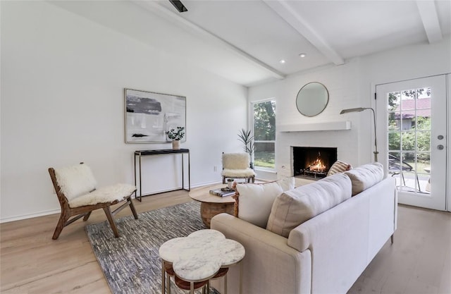 2603 Carlow Dr, Austin, TX 78745 - living area with beamed ceiling, light wood-style floors, a lit fireplace, and baseboards