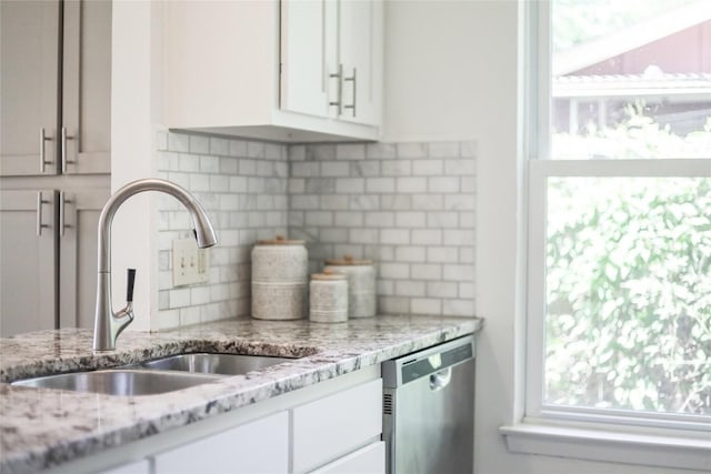 2603 Carlow Dr, Austin, TX 78745 - kitchen with a sink, dishwasher, backsplash, white cabinets, and light stone countertops