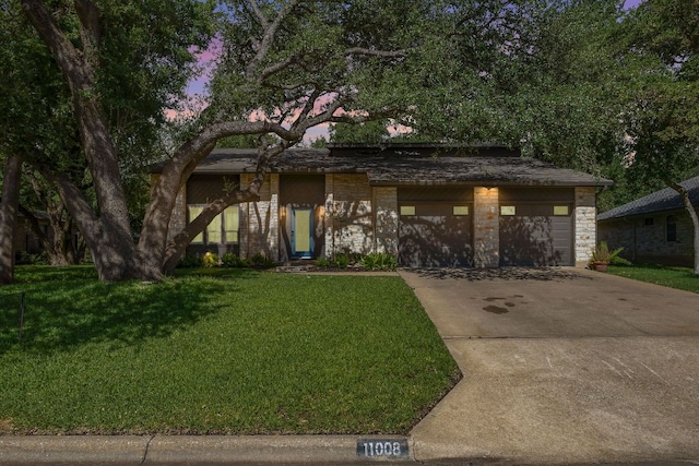 11008 Arch Ter, Austin, TX 78750 - mid-century home with stone siding, a front yard, driveway, and an attached garage