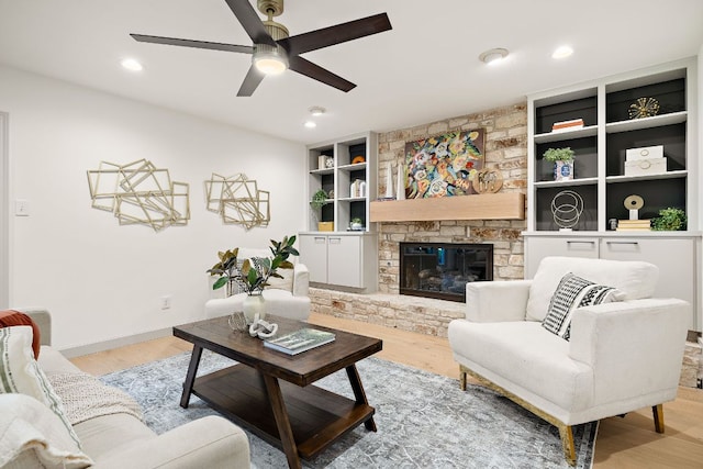 11008 Arch Ter, Austin, TX 78750 - living room with a ceiling fan, light wood finished floors, built in shelves, a stone fireplace, and recessed lighting