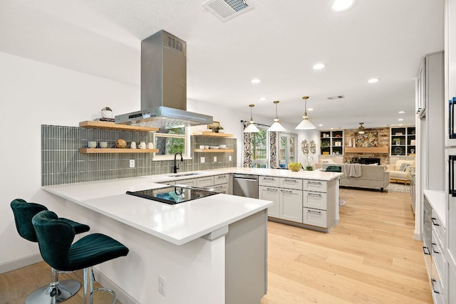 11008 Arch Ter, Austin, TX 78750 - kitchen with a peninsula, stainless steel dishwasher, island range hood, open shelves, and light wood-style floors