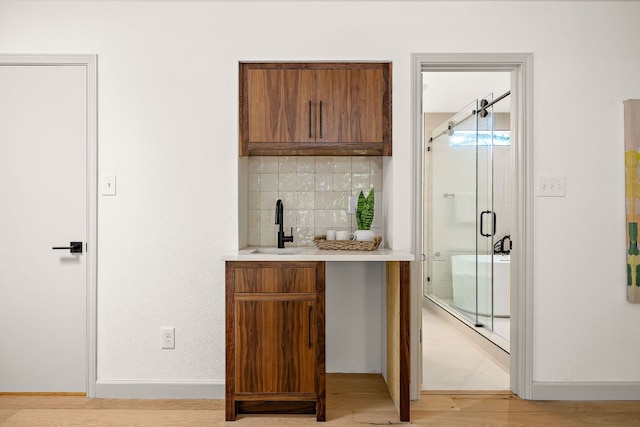 11008 Arch Ter, Austin, TX 78750 - indoor wet bar featuring backsplash, light wood-style floors, and baseboards