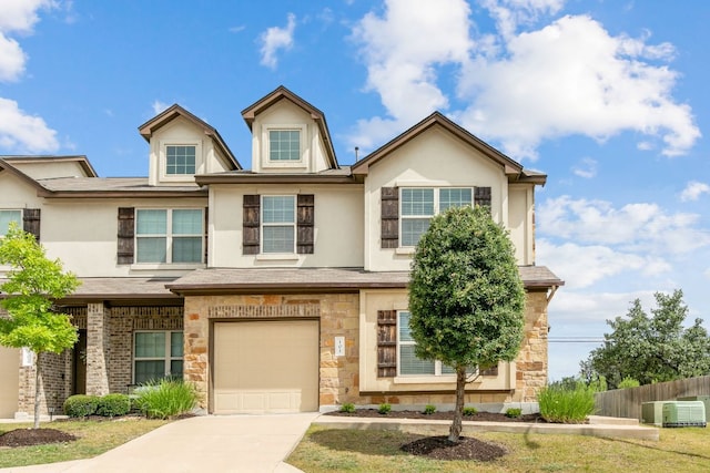 1701 S Bell Blvd Unit 101, Cedar Park, TX 78613 - view of front of property with a garage, concrete driveway, stone siding, and stucco siding