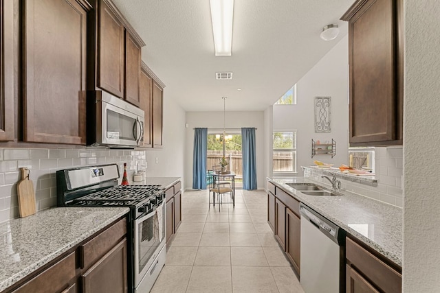 1701 S Bell Blvd Unit 101, Cedar Park, TX 78613 - kitchen with appliances with stainless steel finishes, a sink, backsplash, and light stone countertops