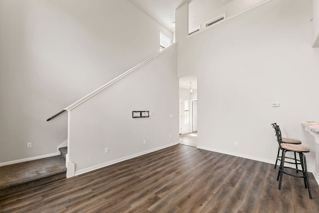1701 S Bell Blvd Unit 101, Cedar Park, TX 78613 - unfurnished living room featuring stairway, dark wood-style floors, baseboards, and a high ceiling