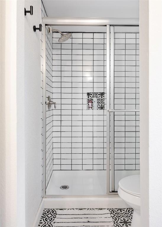 4601 Candletree Ln, Austin, TX 78744 - full bath featuring a stall shower, toilet, and tile patterned flooring
