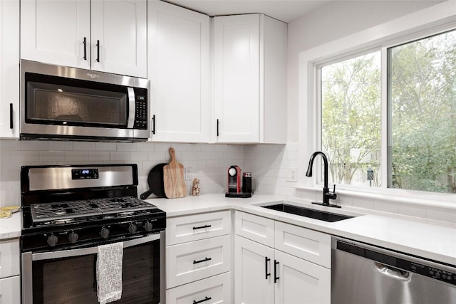4601 Candletree Ln, Austin, TX 78744 - kitchen with appliances with stainless steel finishes, a sink, light countertops, white cabinets, and tasteful backsplash