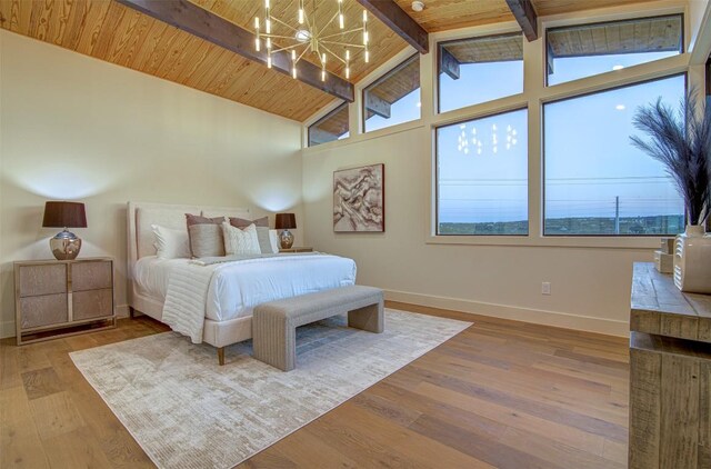 19543 Lakehurst Loop, Spicewood, TX 78669 - bedroom featuring a chandelier, baseboards, multiple windows, wood finished floors, and high vaulted ceiling
