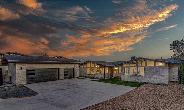 19543 Lakehurst Loop, Spicewood, TX 78669 - view of front of home featuring stone siding, concrete driveway, and a garage