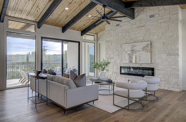 19543 Lakehurst Loop, Spicewood, TX 78669 - living room with a ceiling fan, wood finished floors, plenty of natural light, a stone fireplace, and high vaulted ceiling