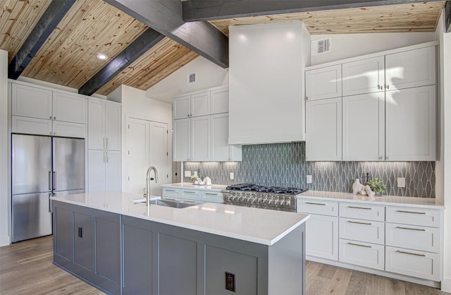 19543 Lakehurst Loop, Spicewood, TX 78669 - kitchen featuring high quality appliances, light countertops, white cabinetry, light wood-type flooring, and backsplash