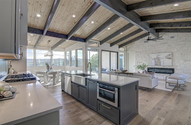 19543 Lakehurst Loop, Spicewood, TX 78669 - kitchen featuring light countertops, wood finished floors, a fireplace, ceiling fan, and wooden ceiling