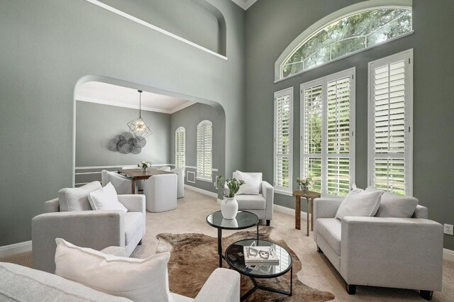 12004 Mira Mesa Dr, Austin, TX 78732 - carpeted living area featuring baseboards, arched walkways, and ornamental molding