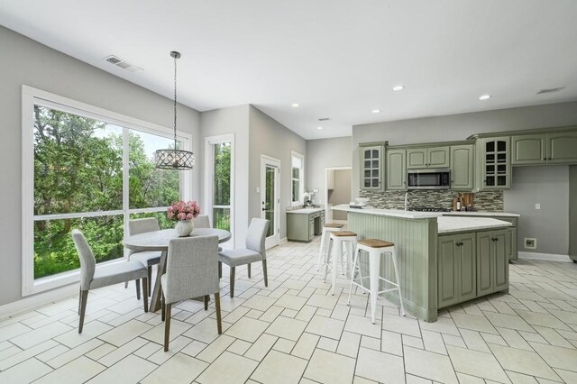12004 Mira Mesa Dr, Austin, TX 78732 - kitchen featuring stainless steel microwave, green cabinets, light countertops, and recessed lighting