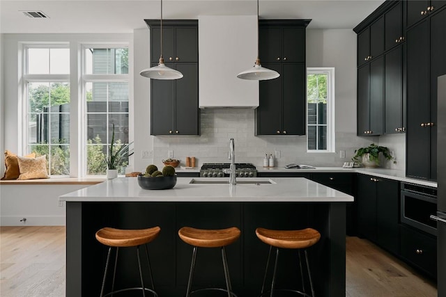 113 Nelray Blvd Unit 2, Austin, TX 78751 - kitchen featuring light wood-style floors, tasteful backsplash, light countertops, and plenty of natural light