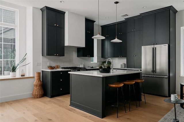113 Nelray Blvd Unit 2, Austin, TX 78751 - kitchen with high end refrigerator, light wood-type flooring, decorative backsplash, light countertops, and recessed lighting