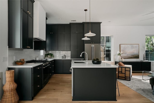 113 Nelray Blvd Unit 2, Austin, TX 78751 - kitchen with freestanding refrigerator, black gas range oven, light wood-style floors, light countertops, and tasteful backsplash
