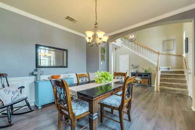 1414 Shamitas Ct, Leander, TX 78641 - dining space featuring stairway, arched walkways, ornamental molding, a chandelier, and wood finished floors