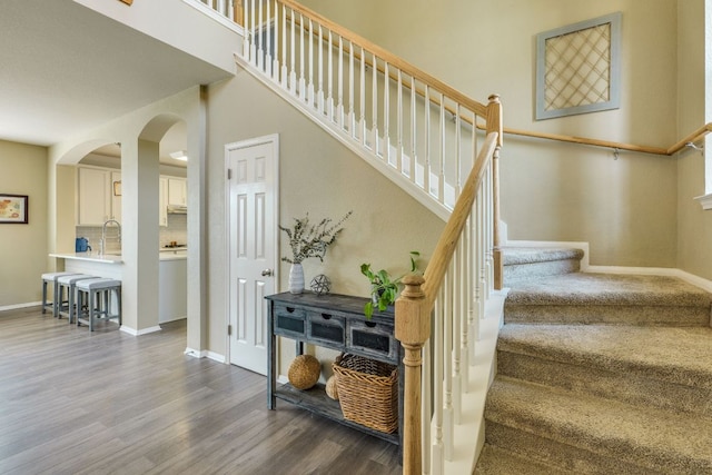 1414 Shamitas Ct, Leander, TX 78641 - stairs featuring wood finished floors, arched walkways, and baseboards
