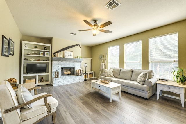 1414 Shamitas Ct, Leander, TX 78641 - living room featuring a ceiling fan, plenty of natural light, a fireplace, and wood finished floors