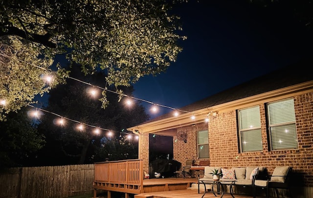 2217 Hilltop Climb Dr, Leander, TX 78641 - back of house at twilight with brick siding, an outdoor living space, and a wooden deck